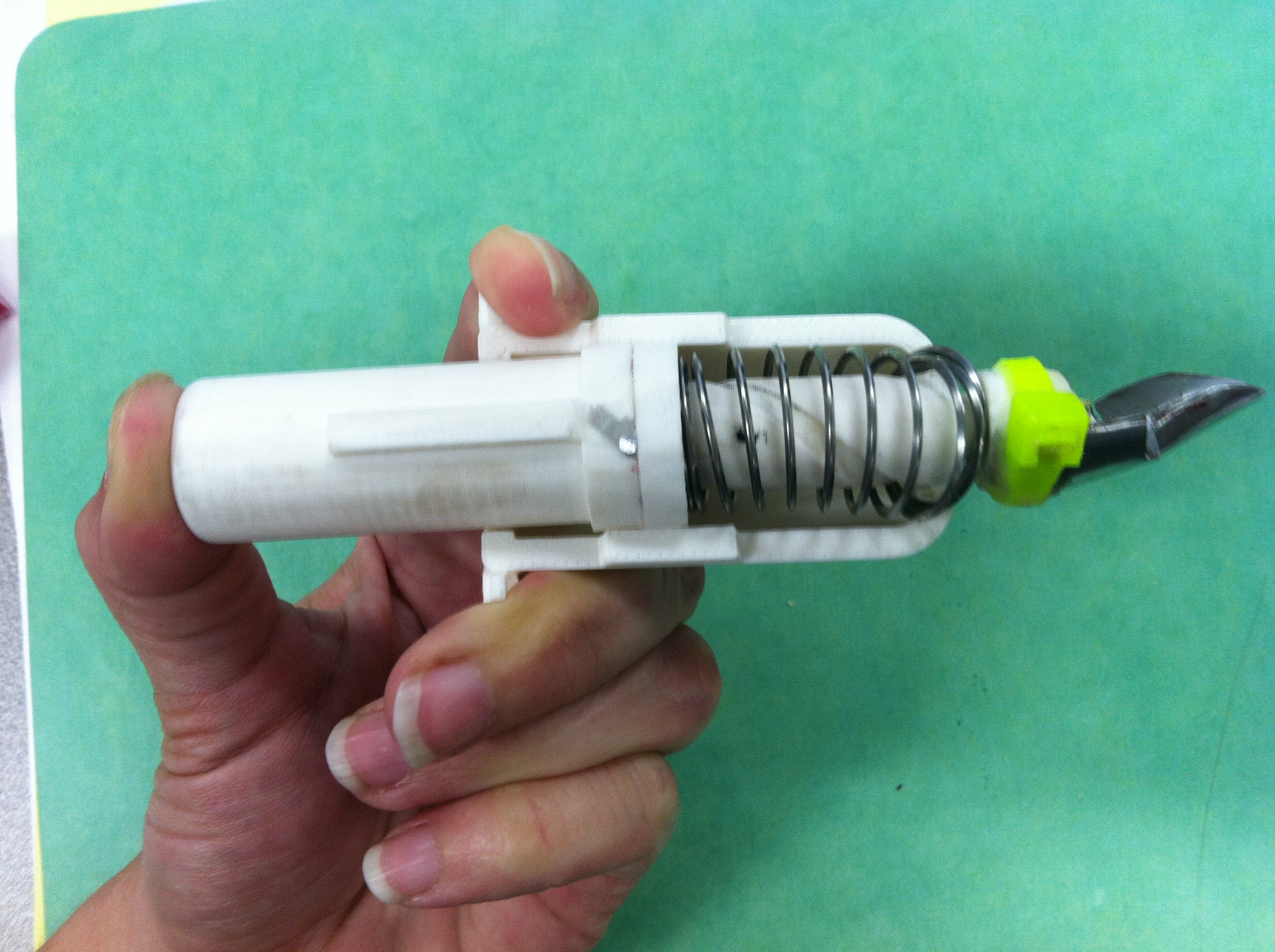 Strawberry huller prototype held in the hand