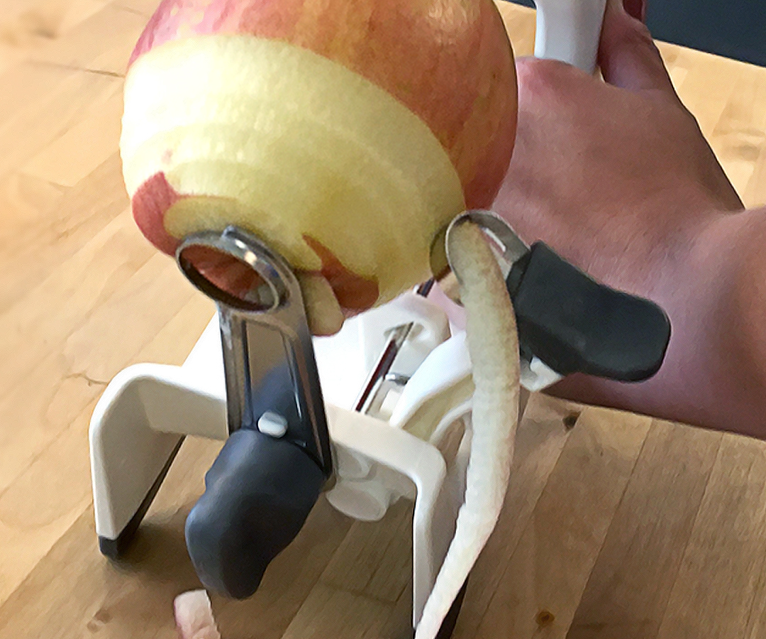 Close view of a peeling blade working on an apple